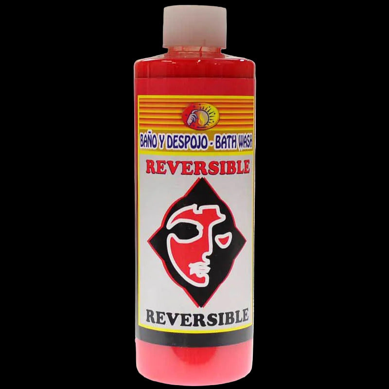 A red plastic bottle with a screw top, labeled 'Reversible' and 'Bath Wash' indicating its use for ritual bathing.