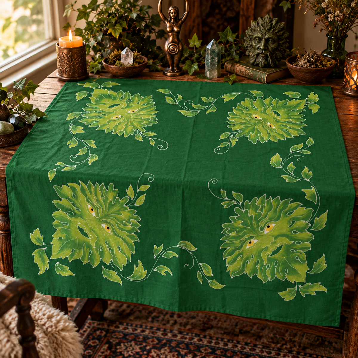 Green Man batik altar cloth featuring four leafy faces and curling vines on a forest-green background, draped over a wooden altar table.
