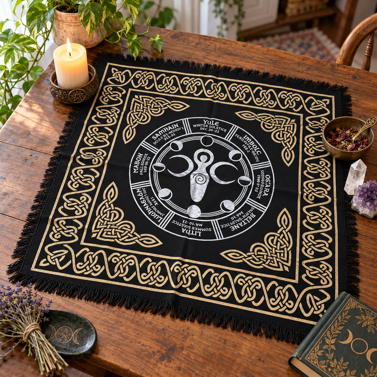 Black Earth Goddess altar cloth with Wheel of the Year, moon phases, gold Celtic knot border, and fringed edges, displayed on a wooden altar table.